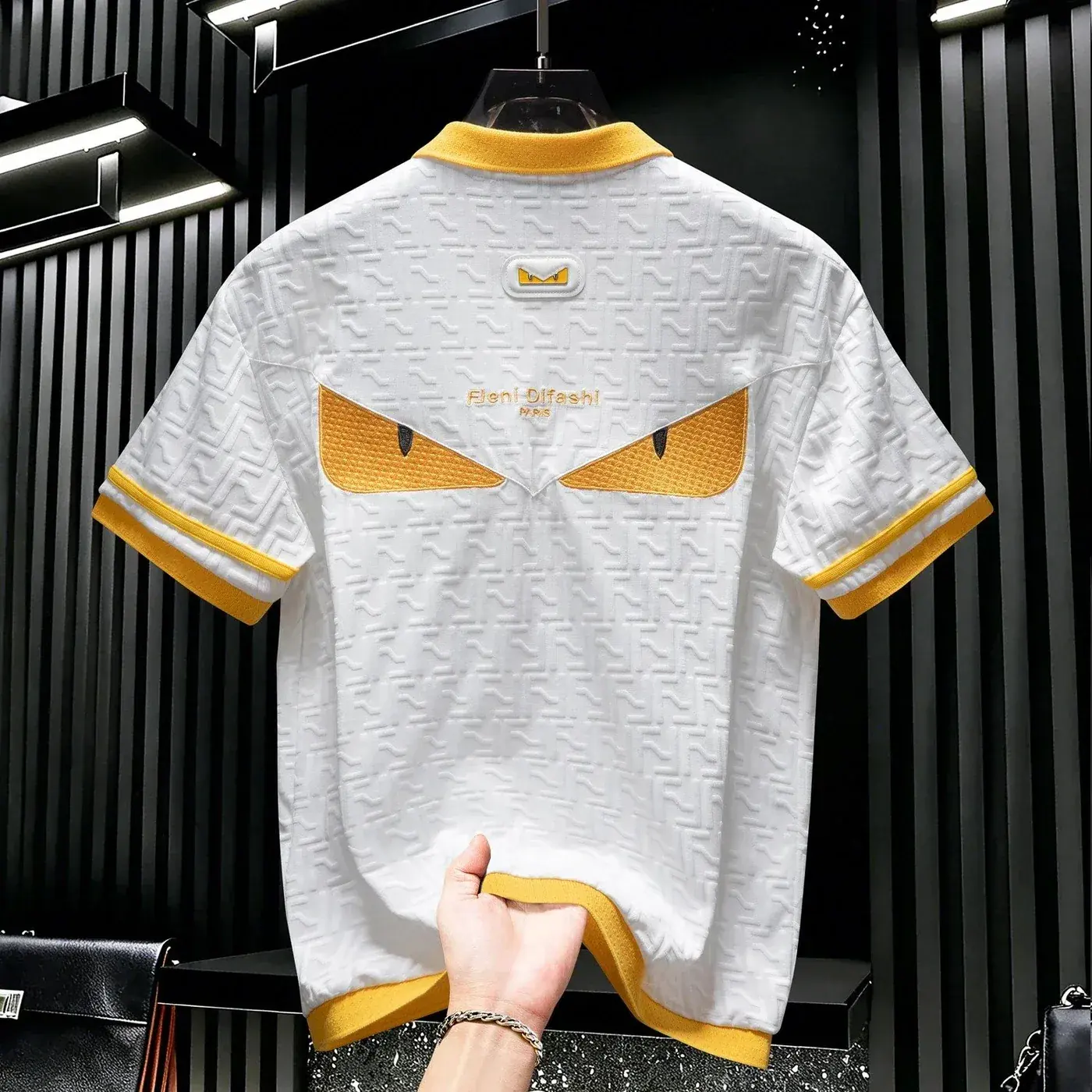 The defining feature of this Fendi-style polo shirt is the "Little Monster" eye motif on the back